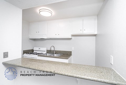 an interior view of a kitchen with white cabinets and a counter top
